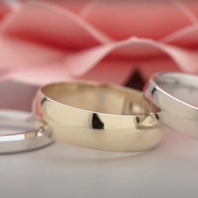 A yellow gold ring with silver rings either side.